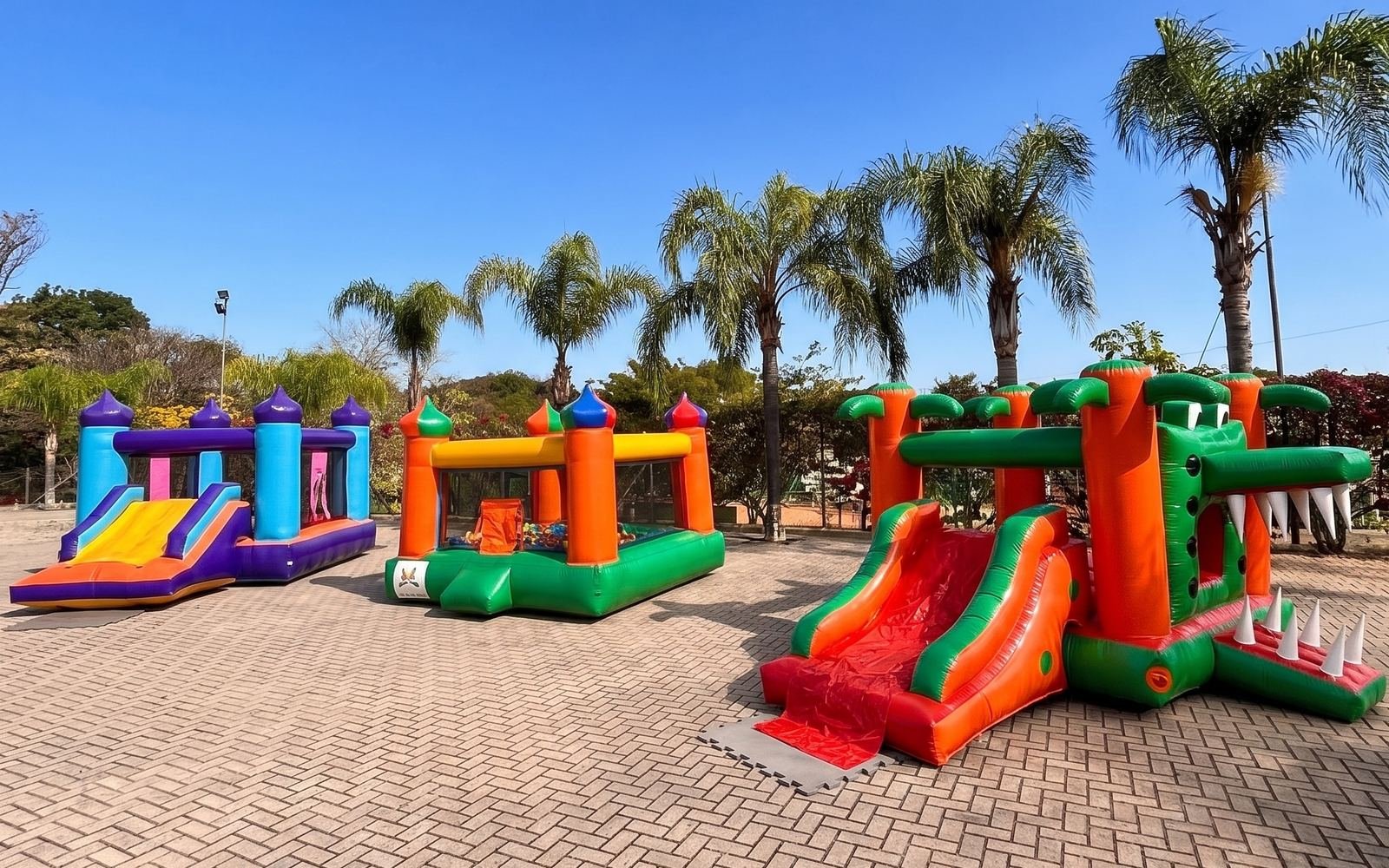 Três brinquedos infláveis da Happy Toy montados lado a lado em um evento em Sorocaba